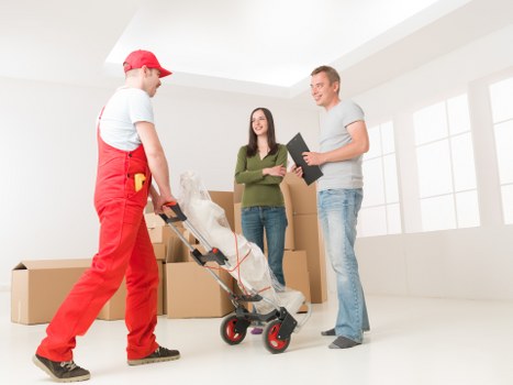 Professional Barnet man with van service loading furniture carefully into a van